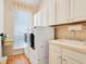 Well-equipped laundry room with ample cabinet storage, a sink, and modern washer and dryer units at 4119 Pecan Ln, Orlando, FL 32812