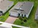 An aerial perspective reveals a well-maintained home with a brick driveway, lush lawn, and green surroundings at 451 Shadow Gorge Way, Eustis, FL 32736