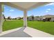 View of the large backyard showcasing a covered patio overlooking the green lawn and neighborhood at 451 Shadow Gorge Way, Eustis, FL 32736