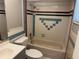 A full bathroom with a tub/shower combo featuring blue and red accent tiles at 4617 Frisco Cir, Orlando, FL 32808