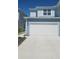 Light blue two-story home with a white garage door and concrete driveway at 4762 Sparkling Shell Ave, Kissimmee, FL 34746
