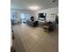 Open-plan living room featuring tile flooring, modern sofas, and sliding glass doors at 5006 Vellacito Way, Davenport, FL 33897