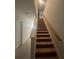 Stairway with carpeted steps and a wooden handrail, leading to the upper level at 5006 Vellacito Way, Davenport, FL 33897