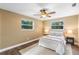 Inviting bedroom with two windows, ceiling fan, neutral decor, and wood-look flooring at 577 Compton Ct, Deland, FL 32724