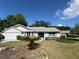 Charming single-story home with light exterior, manicured lawn, and beautiful blue skies at 6042 Wade St, Leesburg, FL 34748