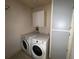 Cozy laundry room features white washer and dryer units with storage at 6042 Wade St, Leesburg, FL 34748