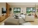 Bright living room featuring an oversized couch, large windows with a view, and hardwood floors at 6168 Sw 154Th St, Ocala, FL 34473