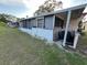 View of the exterior including screened-in patio and grassy yard at 68 S Marbrisa Way, Kissimmee, FL 34743