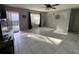 Well-lit living room with tile floors, ceiling fan, and view of the entrance at 68 S Marbrisa Way, Kissimmee, FL 34743