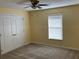 Bright bedroom featuring neutral carpet, a ceiling fan, and a window providing natural light at 697 Winding Lake Dr, Clermont, FL 34711