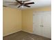 Cozy bedroom featuring carpeted floors, a ceiling fan and a double door closet at 697 Winding Lake Dr, Clermont, FL 34711