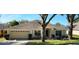 Charming single-story home with a well-maintained lawn and an attached two-car garage at 697 Winding Lake Dr, Clermont, FL 34711