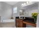 Bathroom featuring large tub, dark granite countertops, and vanity with adjacent seated makeup area at 721 Lake Cove Pointe Cir, Winter Garden, FL 34787