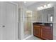 Modern bathroom with a glass shower and a wood vanity with a black countertop at 721 Lake Cove Pointe Cir, Winter Garden, FL 34787