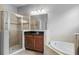Bright bathroom showcasing a glass shower, soaking tub, and dark cabinets with granite countertops at 721 Lake Cove Pointe Cir, Winter Garden, FL 34787
