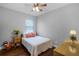 Cozy bedroom with hardwood floors, a ceiling fan, and natural light from the window at 721 Lake Cove Pointe Cir, Winter Garden, FL 34787