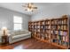 Inviting bedroom featuring hardwood floors, a ceiling fan, a large window and lots of book shelves at 721 Lake Cove Pointe Cir, Winter Garden, FL 34787