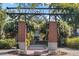 Centennial Plaza sign with brick pillars, wrought iron archway, and hanging purple flowers at 721 Lake Cove Pointe Cir, Winter Garden, FL 34787