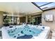 Backyard covered patio with a large hot tub, seating area, ceiling fan, and outdoor lighting at 721 Lake Cove Pointe Cir, Winter Garden, FL 34787