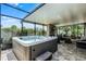 Enjoy this backyard patio with a covered hot tub, living area, and fireplace for outdoor relaxation at 721 Lake Cove Pointe Cir, Winter Garden, FL 34787