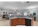 Open concept kitchen with granite countertops, wood cabinets, black appliances, and view to the living area at 721 Lake Cove Pointe Cir, Winter Garden, FL 34787