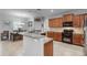 Well-lit kitchen with granite counters, wood cabinets, and a dining area for casual meals at 721 Lake Cove Pointe Cir, Winter Garden, FL 34787
