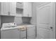 Bright laundry room features modern appliances and ample storage with white cabinets and a nearby door at 721 Lake Cove Pointe Cir, Winter Garden, FL 34787