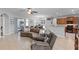 Open-concept living space with tile floors, ceiling fan, leather furniture, and sliding doors to the outdoor patio at 721 Lake Cove Pointe Cir, Winter Garden, FL 34787