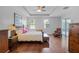 Large main bedroom features wood floors, ceiling fan, and a cozy sitting area near sliding glass doors at 721 Lake Cove Pointe Cir, Winter Garden, FL 34787