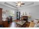 This spacious home office features a piano, hardwood floors, and natural light through a window at 721 Lake Cove Pointe Cir, Winter Garden, FL 34787