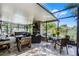 Enclosed patio with a hot tub, outdoor dining set, comfortable seating, and fireplace at 721 Lake Cove Pointe Cir, Winter Garden, FL 34787
