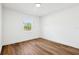 Bright bedroom features wood-look floors, white walls and trim, a window with natural light, and base trim at 730 W Swoope Ave, Winter Park, FL 32789