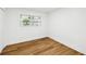 Bright bedroom features wood-look floors, white walls and trim, a window with natural light, and base trim at 730 W Swoope Ave, Winter Park, FL 32789