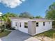 A view of the home's side showcasing the fresh white paint, large windows, and well-maintained landscaping at 730 W Swoope Ave, Winter Park, FL 32789