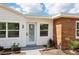 Close up of the exterior featuring modern wood siding, a secured glass door, and a manicured front lawn at 730 W Swoope Ave, Winter Park, FL 32789