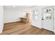 Bright living space featuring wood-look floors, white walls, and a view into the kitchen area through a modern doorway at 730 W Swoope Ave, Winter Park, FL 32789