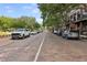 Picturesque street lined with parked cars, mature trees, and brick-paved road with building facades at 730 W Swoope Ave, Winter Park, FL 32789