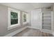 Bedroom with hardwood floors, two windows, and a built-in bookshelf at 821 E Lemon Ave, Eustis, FL 32726