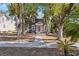 Beautiful gray home with red door framed by mature trees and a charming walkway at 821 E Lemon Ave, Eustis, FL 32726