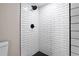 Modern shower featuring white subway tile walls and black hexagon tile flooring at 821 E Lemon Ave, Eustis, FL 32726