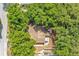 Aerial shot revealing mature trees surrounding a home featuring a brown roof and an outdoor patio at 8316 Granada Blvd, Orlando, FL 32836