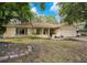 Single-story home with a well-manicured lawn and mature trees, offering both curb appeal and shade at 8316 Granada Blvd, Orlando, FL 32836