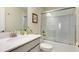 Bright bathroom featuring a shower-tub combo with glass doors and a white vanity with modern fixtures at 901 Ocean Course Ave, Davenport, FL 33896