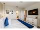 Well-lit bedroom with a white dresser, a large bed with blue accents, and minimalist decor for peaceful rest at 901 Ocean Course Ave, Davenport, FL 33896