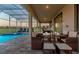 Covered patio with a complete dining set next to a swimming pool and lounge chairs at 901 Ocean Course Ave, Davenport, FL 33896