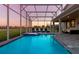 Enclosed swimming pool and spa with ample seating and view of the backyard and lawn at 901 Ocean Course Ave, Davenport, FL 33896