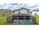 A screened-in backyard pool and spa provide outdoor enjoyment at this modern two-story home at 901 Ocean Course Ave, Davenport, FL 33896