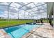Backyard screened-in pool features a spa and a sundeck for lounging and catching some rays at 901 Ocean Course Ave, Davenport, FL 33896
