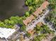 Aerial view of a condo complex with a lake, lush landscaping, parking, and red tiled roofs at 960 Mooring Ave # 202, Altamonte Springs, FL 32714