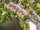 Aerial view of condo complex with red tiled roofs surrounded by lush landscaping and lake at 960 Mooring Ave # 202, Altamonte Springs, FL 32714